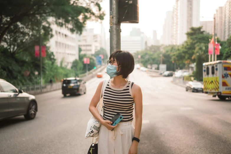 the woman is wearing a face mask on the street