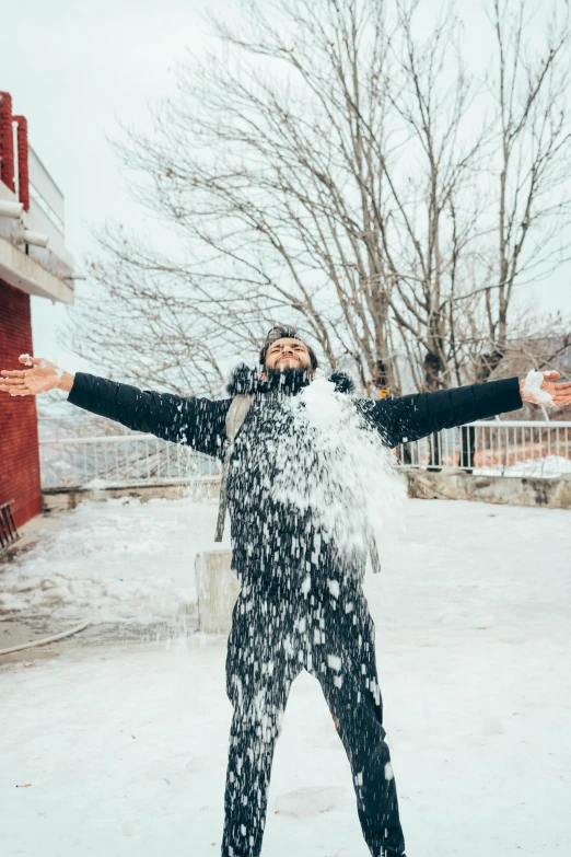 a person is throwing snow on his face in the cold