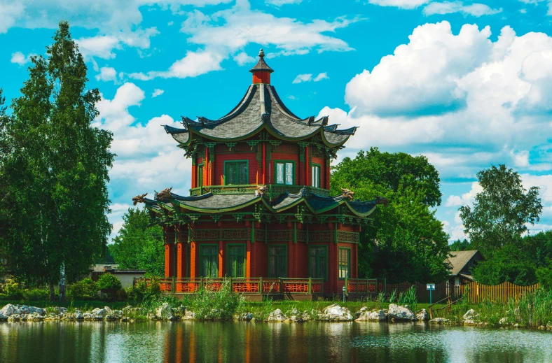 an old pagoda building with its roof opened over looking the water