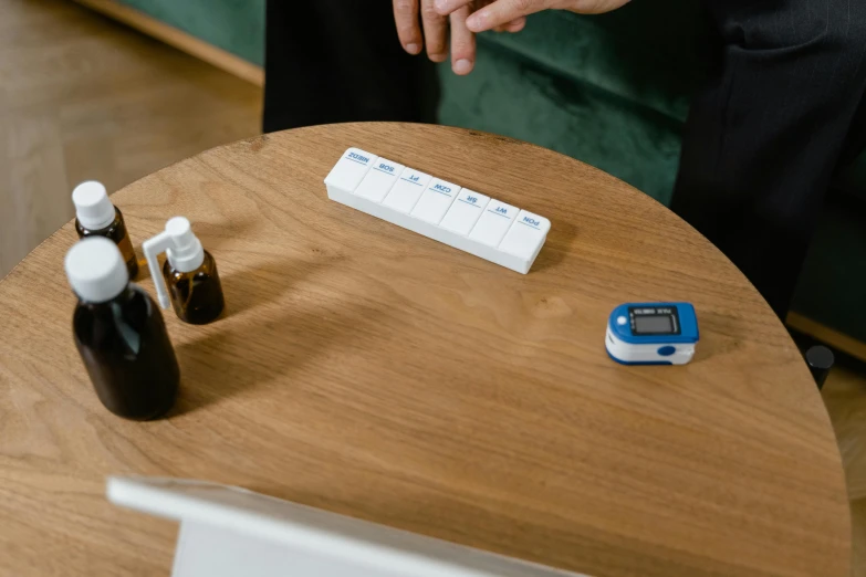 a man looking at a medicine container next to an alarm clock