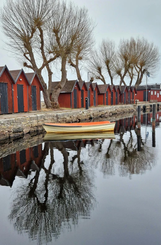 boats are in the water next to small red houses