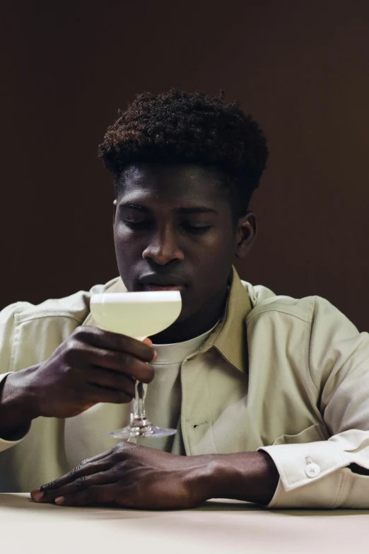 a man with an alcohol glass eating soing