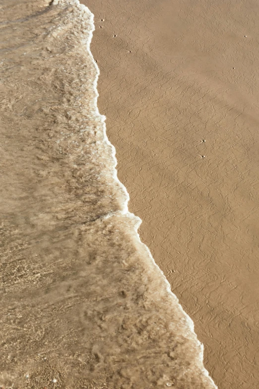 someone is standing on the beach shore with their surfboard