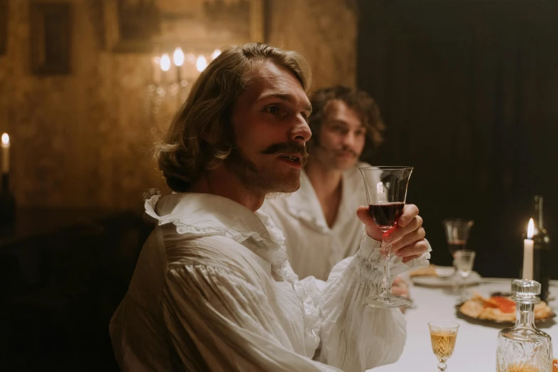 two people sitting down at a table with champagne