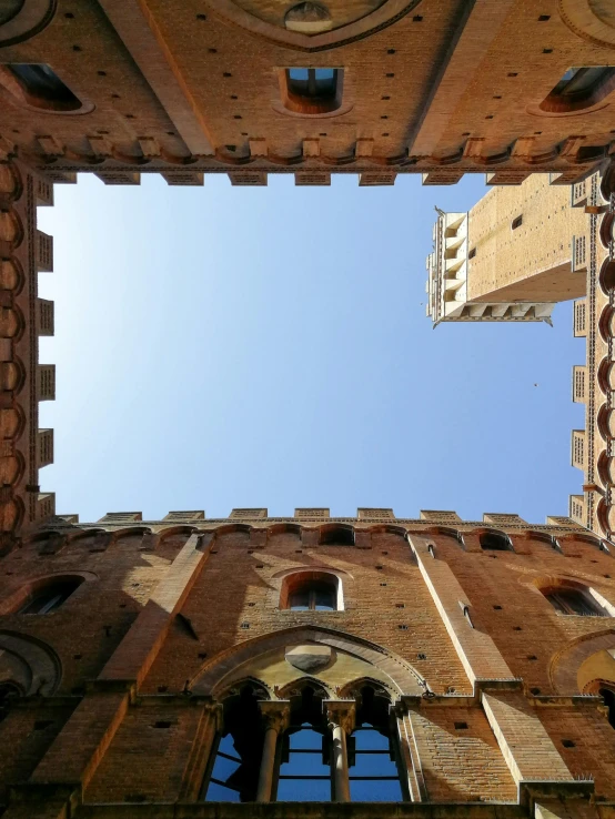 the top of a tall building with multiple windows and balconies