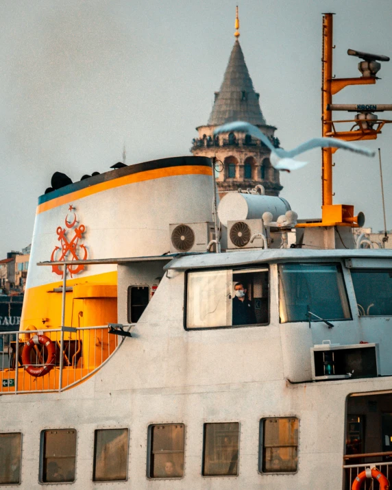 an old boat sitting in the water near a tower