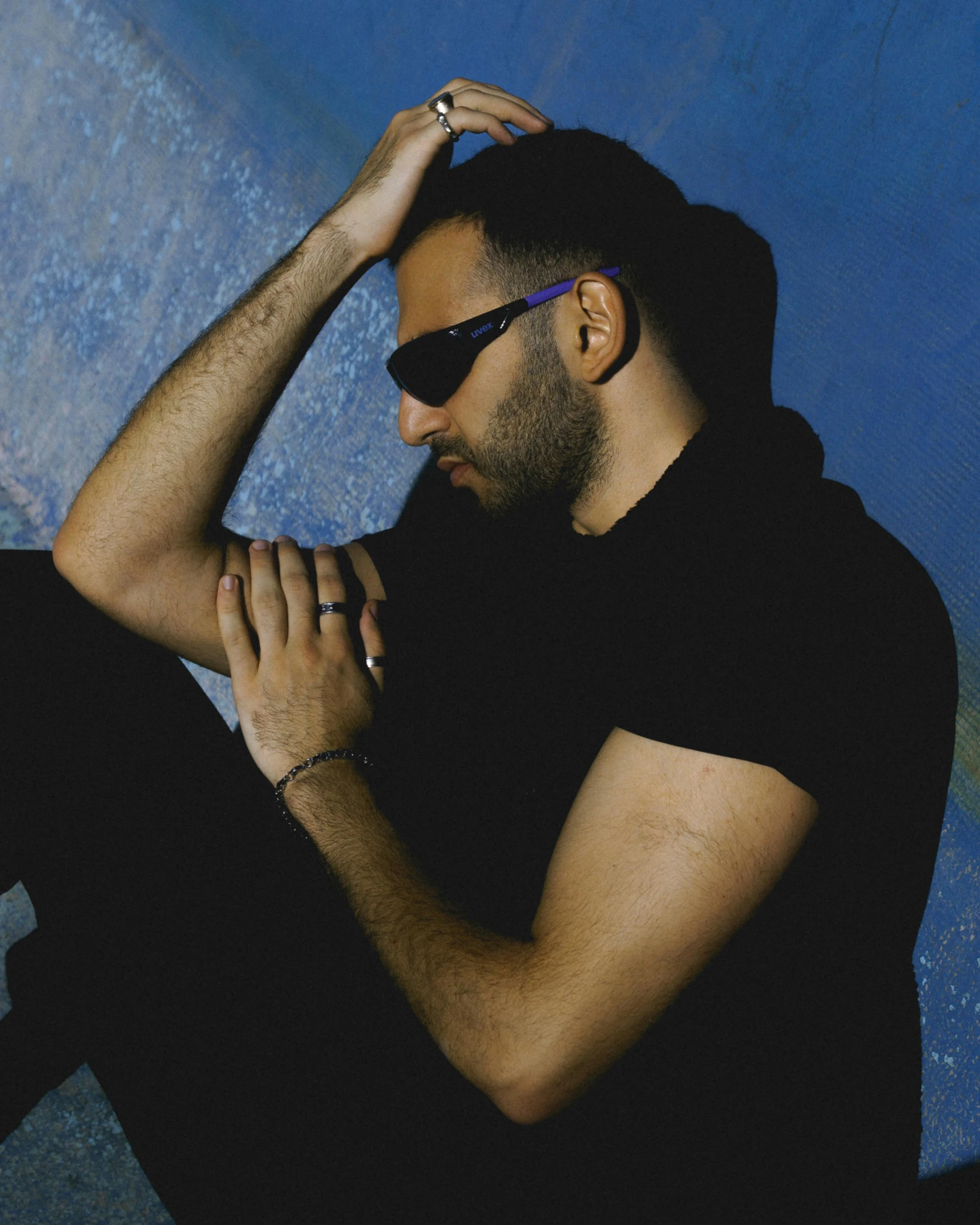 a man wearing sunglasses in front of a blue background