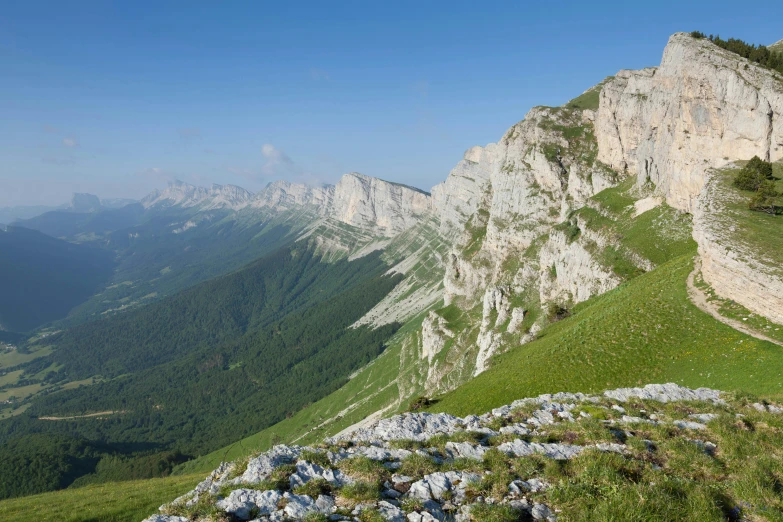 a rocky hillside with large mountains in the background