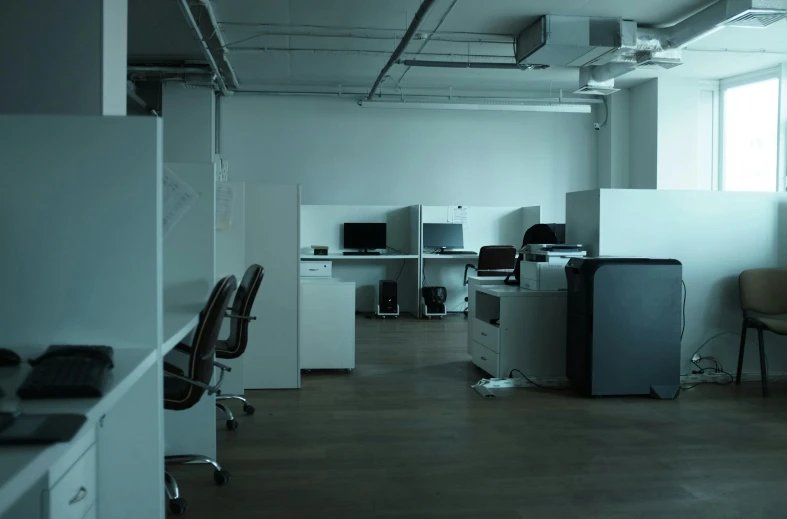 an office is empty and has computers and chairs