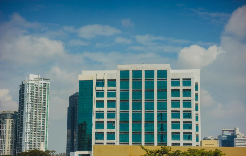 a large el building with blue windows and trees in front