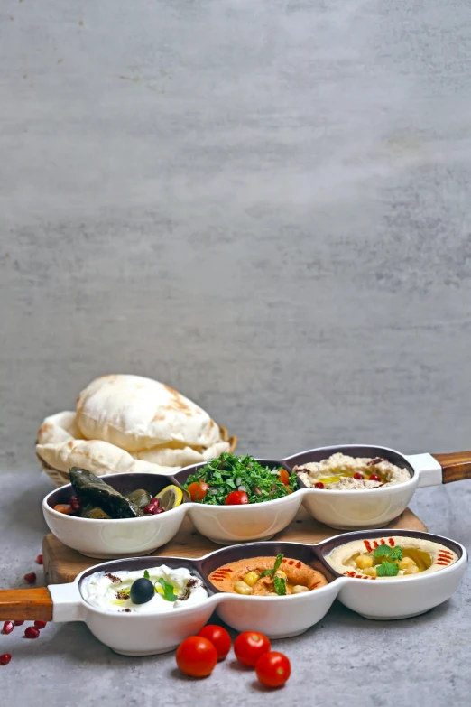 a tray topped with different kinds of bowls next to other dishes