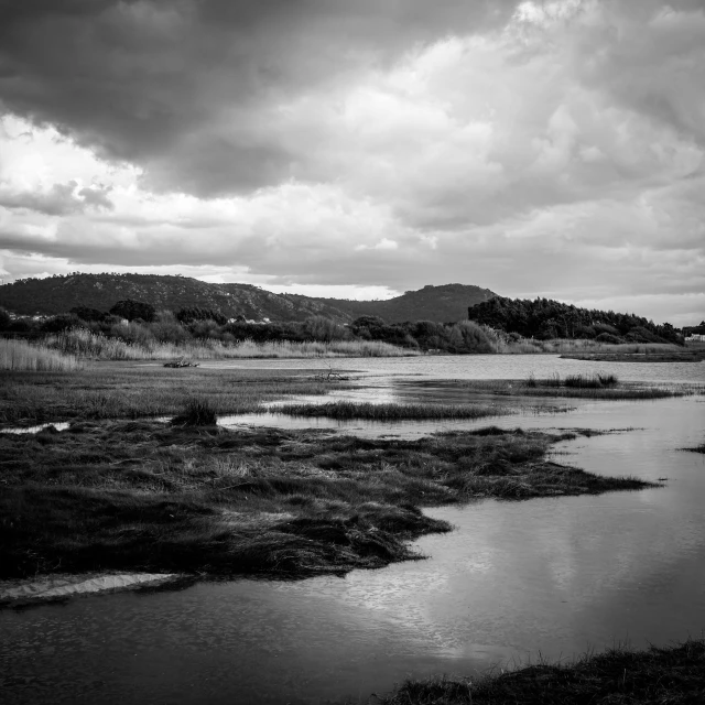 dark landscape with a river and lots of hills in the background