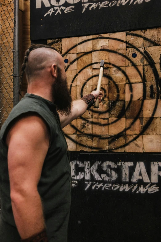 man pointing at darts in target with grungy background