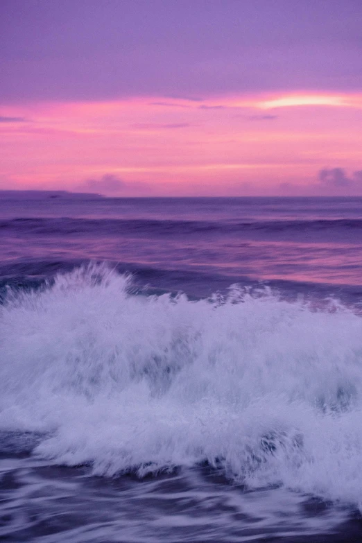 an ocean wave is crashing into a beach