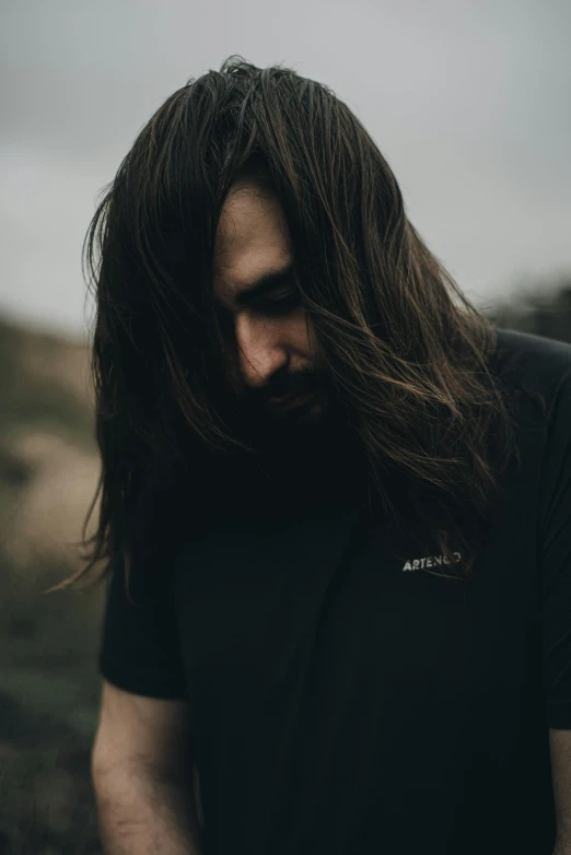 a man with long hair standing in front of the camera