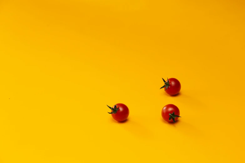 three whole and three whole tomatoes on a yellow background