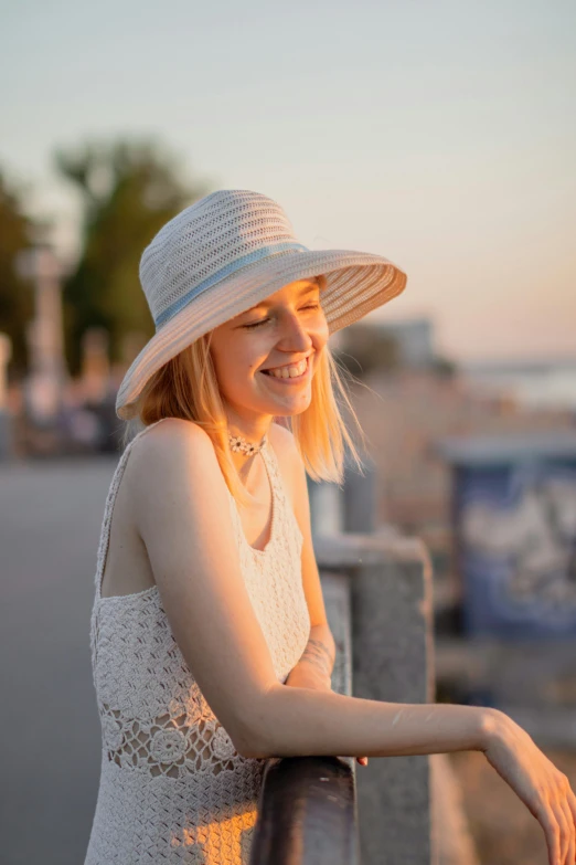 young beautiful woman standing near railing in white top