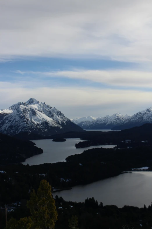 mountains are surrounding a body of water with a lot of snow