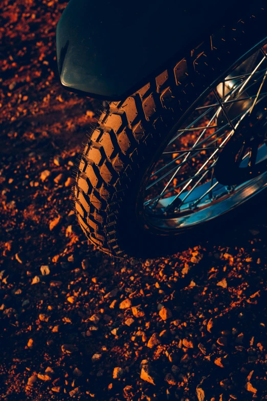 the tire of a motorcycle is on top of dirt