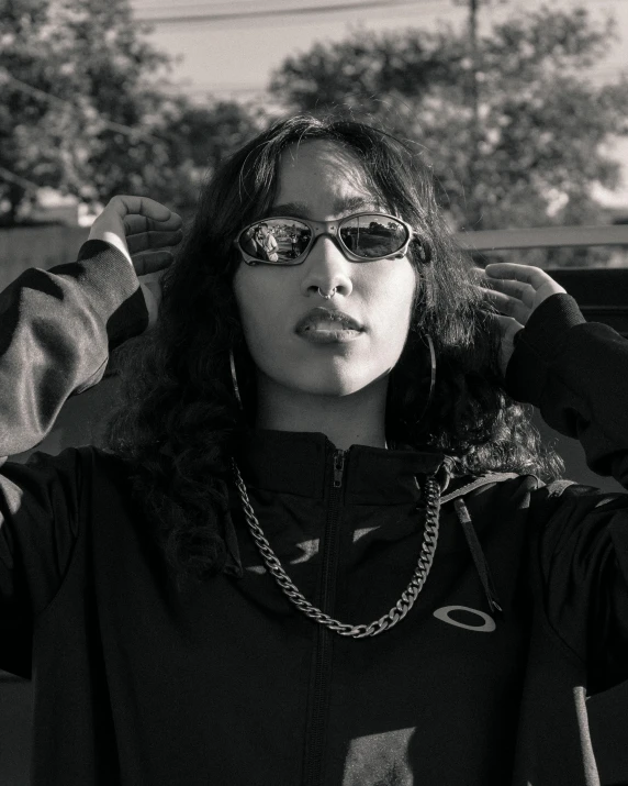 a woman with sunglasses holding her head in the air