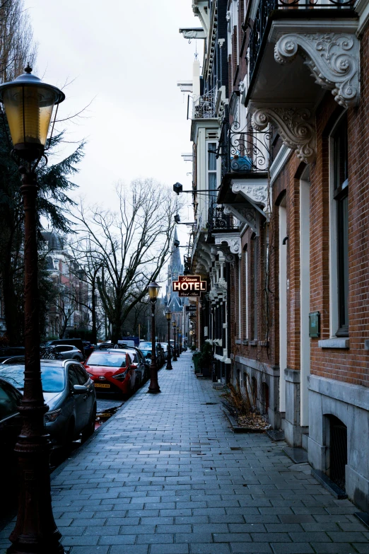 a narrow street is seen with bricked building