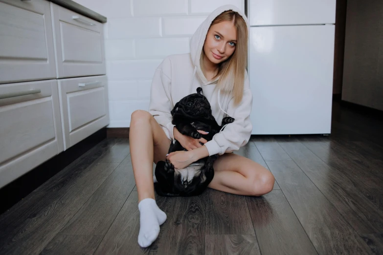 a girl sitting on the floor holding a dog