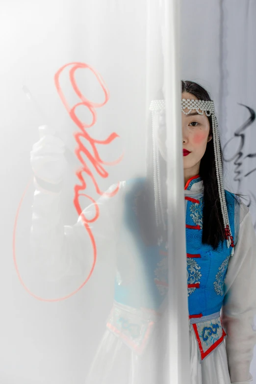 a woman in chinese costume drawing on the wall