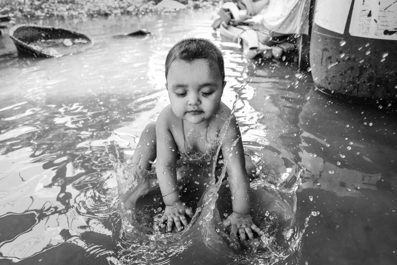 a  standing in water playing with a hose