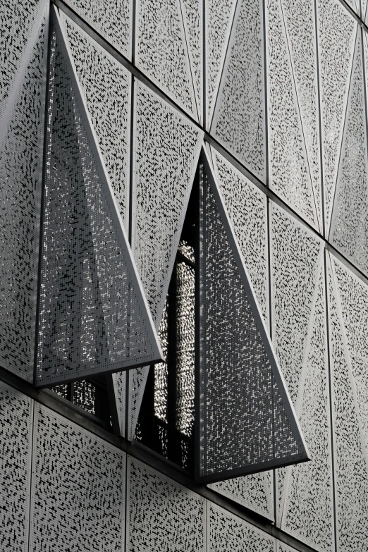 two triangular geometrically shaped objects on the side of a building