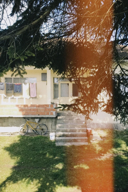 a yellow bike sits outside of a yellow house