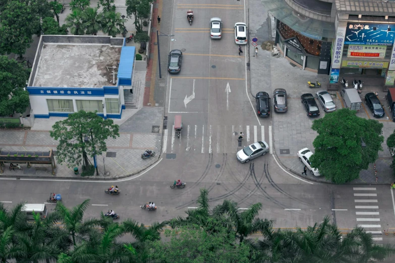 a street view looking down on several different cars parked in the street