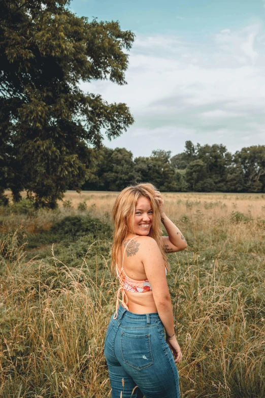 a woman posing for a po in the middle of some tall grass