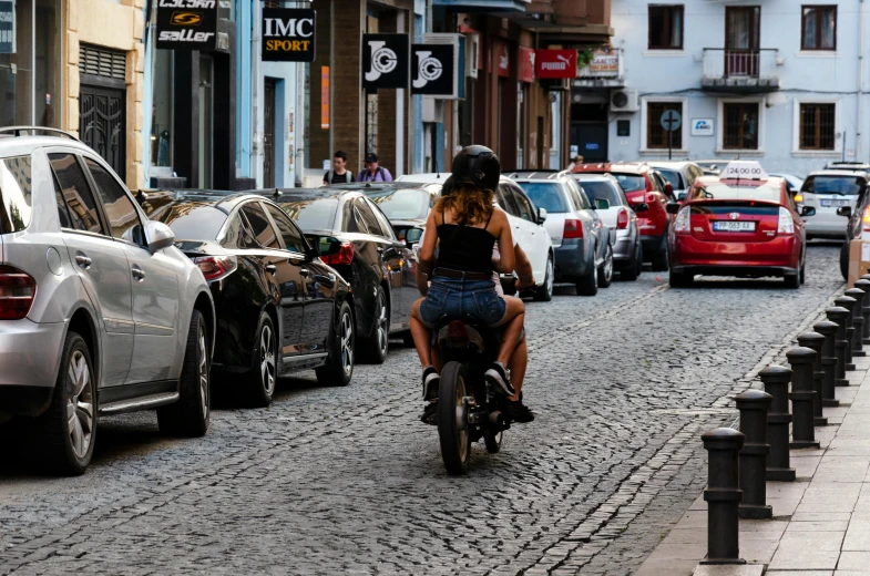 a person riding a motorcycle down a street with many cars