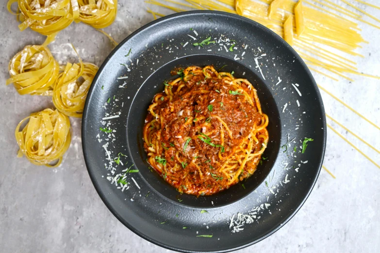 a plate with pasta and yellow glasses sitting on a table