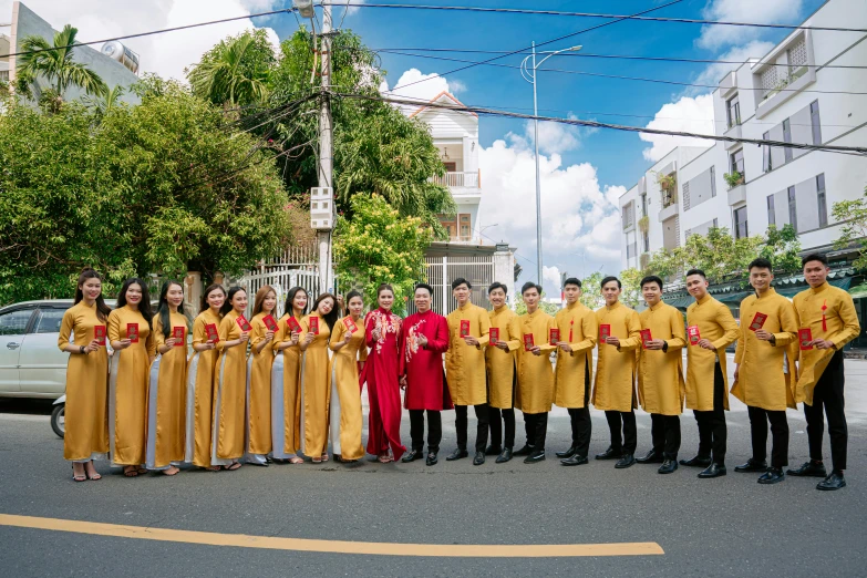 people in orange outfits are standing on the side of the street