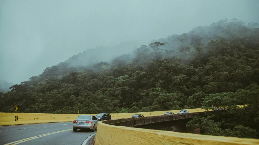 a car is driving up to a mountain with trees