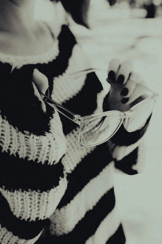 a woman in striped sweater holding glasses