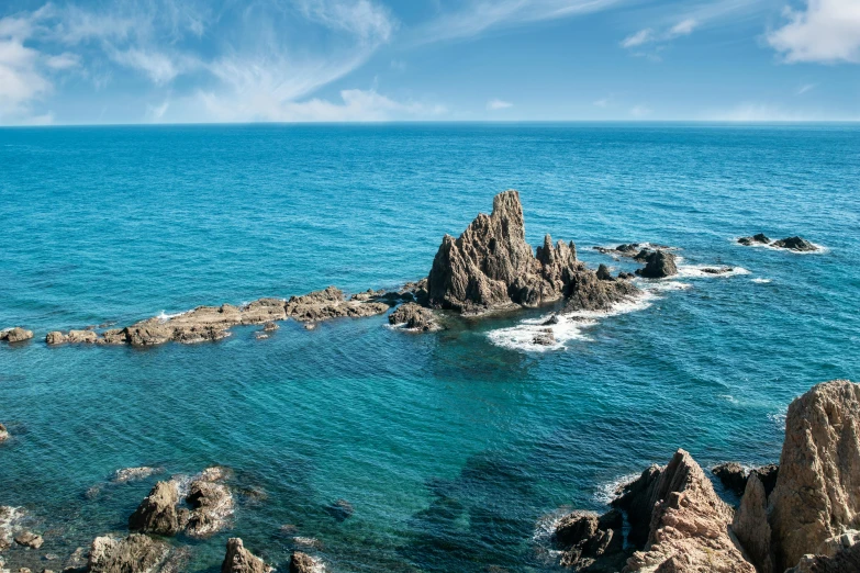 a beach area with several small rocks on the ocean