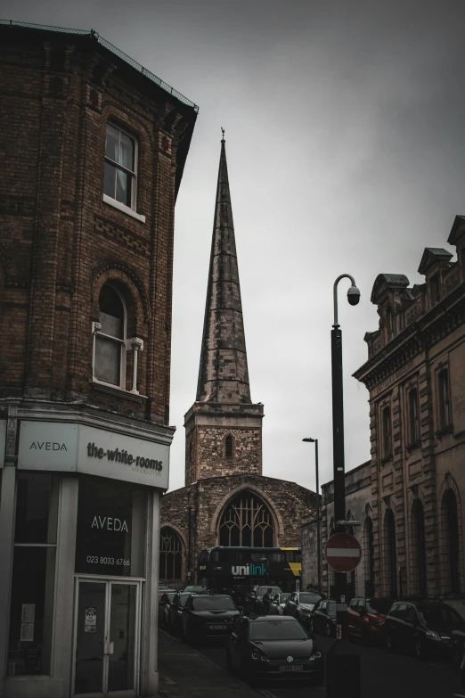 a church steeple and building on the corner of an old town street