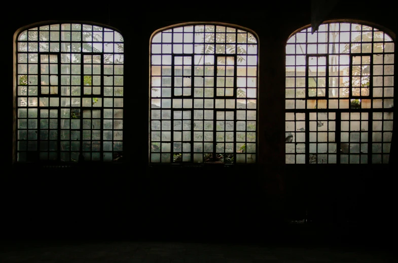 a black room with three windows showing outside