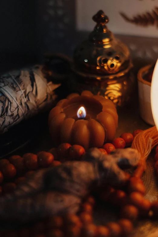 a lit candle sits among candles and other items