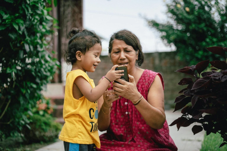 a woman sitting down holding a phone next to her