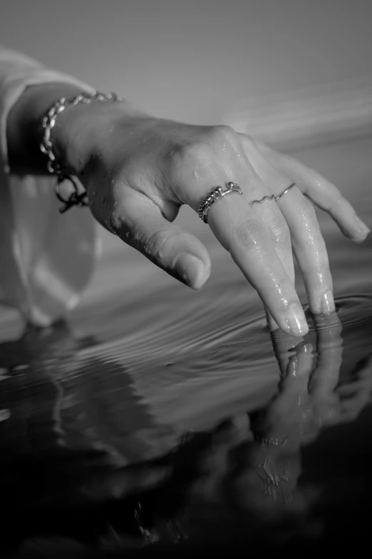 the hand is reaching out from a body of water