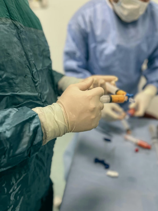 two surgeons and one is taking  out of a small tube