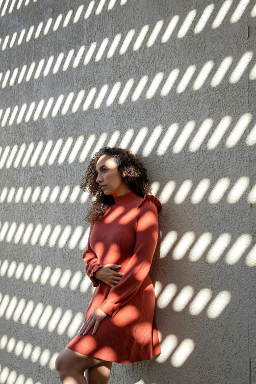 a woman poses in a long sleeved dress and a short boot