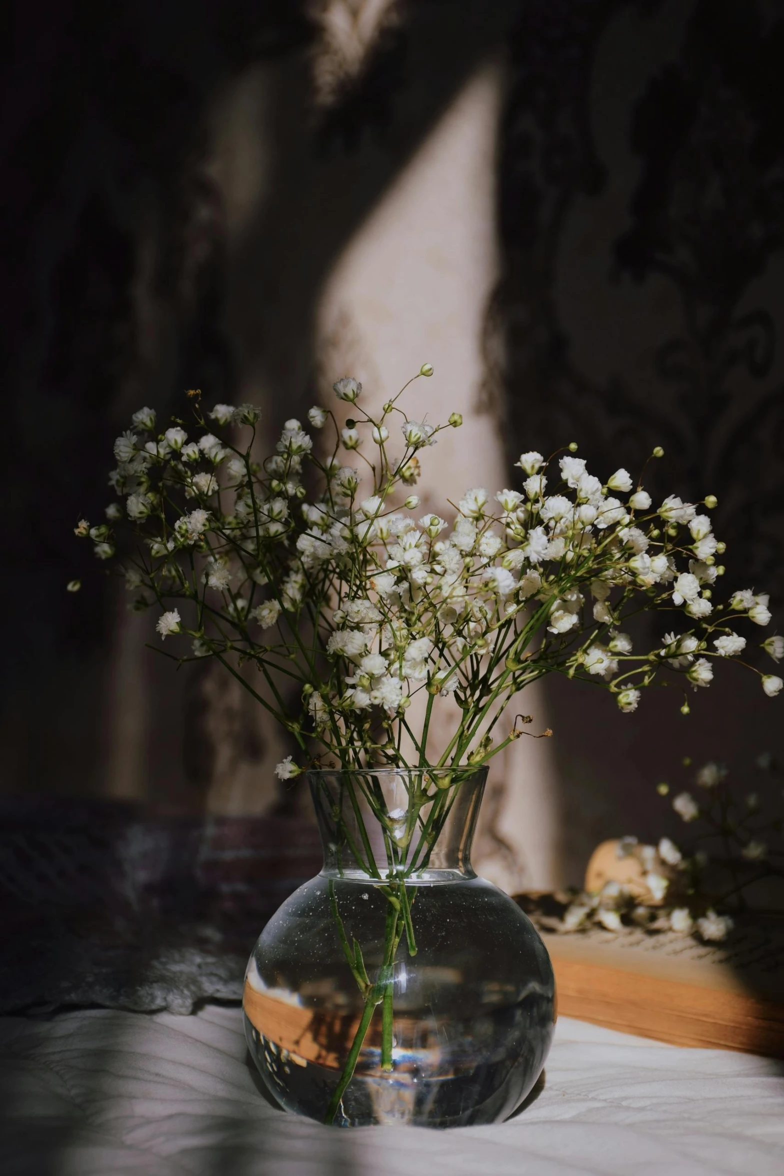 a glass vase filled with white flowers sitting on a table