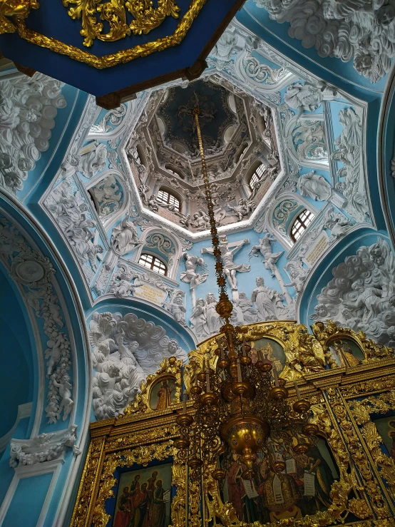 the ceiling of a large building with some golden decorations