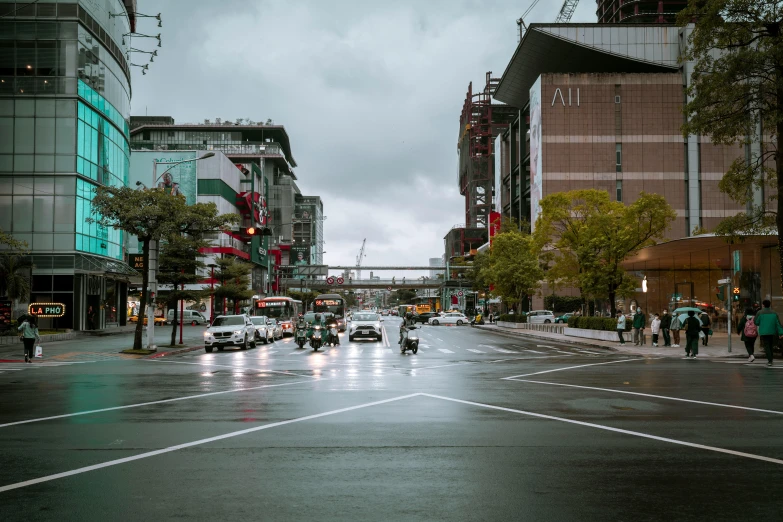 a wet street in a downtown area with many people