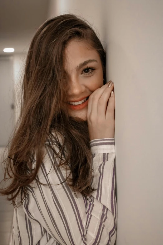 a woman is posing against the wall while smiling