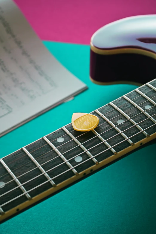 an acoustic guitar with a small pick on the neck